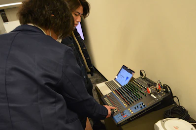 会場の音響操作をスタッフが説明