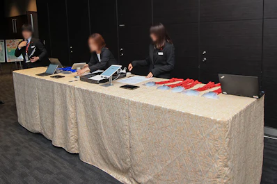 試食会会場前に受付ブース、受付スタッフを配置