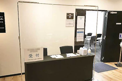 受付には感染対策としてアクリルパーテーションを設置